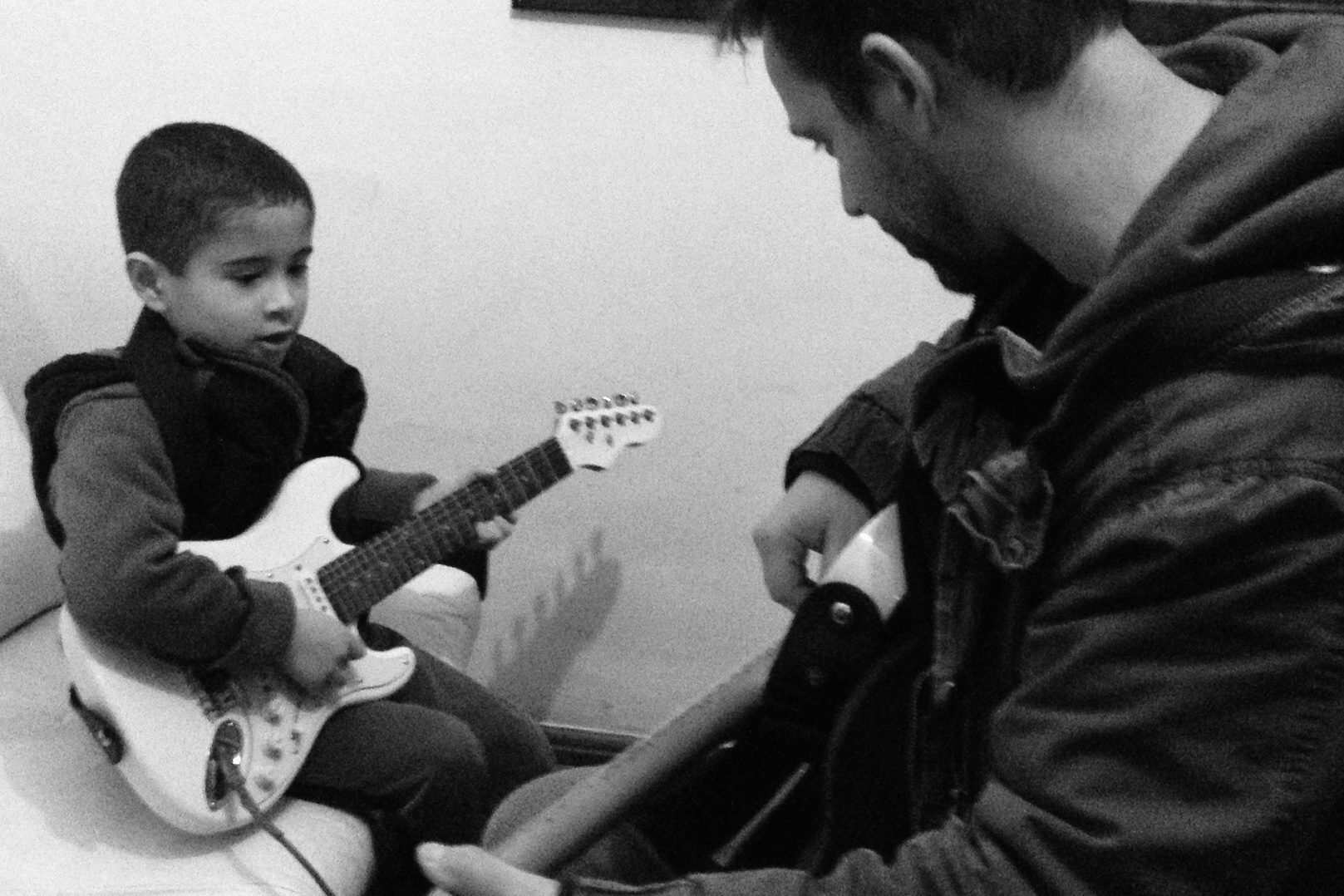 Criança aprendendo guitarra com Denis Delphin em Granja Viana
