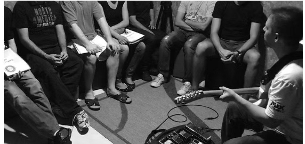 Denis Delphin conduzindo workshop de guitarra em roda com alunos